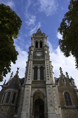 Fototapeta na wymiar Une vue de face de l'église Saint-Benoît avec des arbres au Mans.