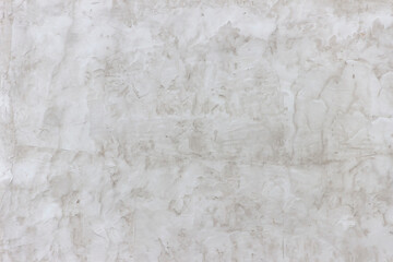 Shabby wall of an old house with uneven crumbling plaster. Yellow-gray abstract texture.
