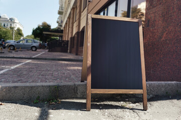 Street restaurant menu with empty black space in wooden frame