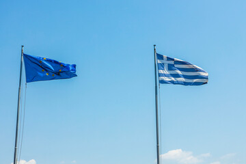 Beautiful view of Greece and Europe flags on blue sky background. Greece. 