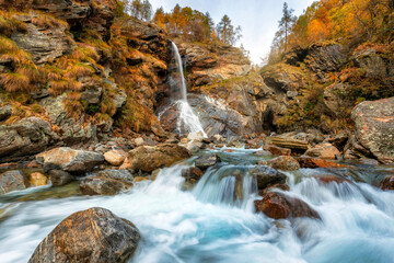Beautiful autumn landscape with yellow trees and waterfall