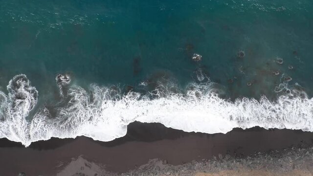Top view of black beach. Drone shot above black beach in Tenerife. Aerial view of ocean waves and coast landscape