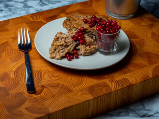 Traditional Finnish cuisines; closeup of a liver caseroll dish on a plate with fresh lingonberries...