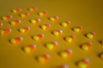 Colorful Halloween candies on yellow background