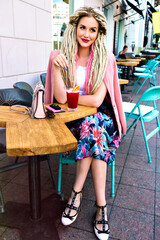 Young pretty smiling woman posing at outdoor city cute cafe