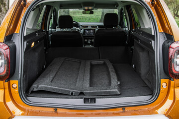 Huge, clean and empty car trunk of a modern compact suv. Rear view of a SUV car with open trunk and folded passenger seats.