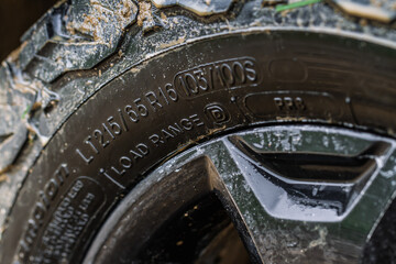 Close up view of snowy tire with tire width, height and wheel diameter designation. Winter tire...