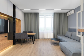 Modern luxury stylish apartment interior in pastel colors. a very bright room with huge windows filled with daylight. blue walls, wooden parquet floors