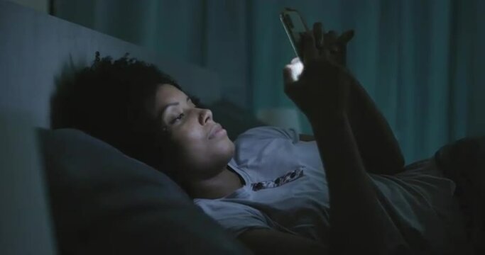 Sleepless woman connecting with her phone at night