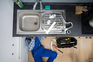 Plumber Fixing Kitchen Pipes