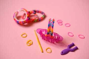 Bracelets, baubles and weaving tools from colored rubber bands. Mini Loom Monster Tail on Pink...