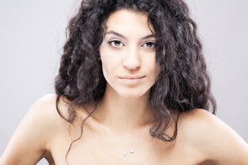 Beautiful brunette girl with long curly hair, studio portrait