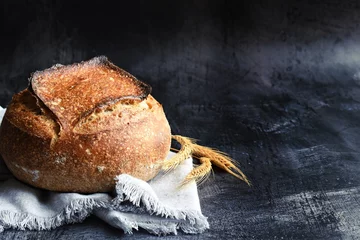 Tuinposter Homemade sourdough bread on the dark background © topotishika