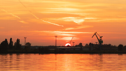 sunset in the port against the backdrop of the crane in the city of Plock