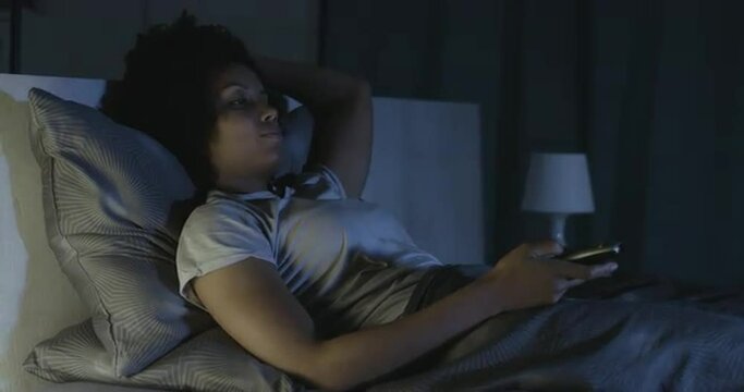Sleepless woman watching TV late at night