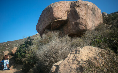 A Woman Hiker Gazing at a Huge Boulder in the California Desert on a Hike Near Pioneer Town, California