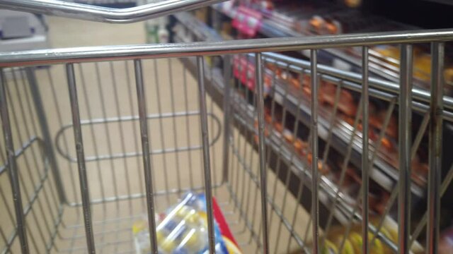 Detail of a pushing trolley shopping in a supermarket