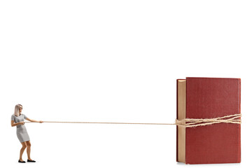 Full length profile shot of a woman in a casual dress pulling a book with a rope