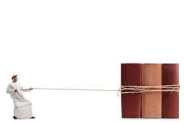 Full length profile shot of a man in ethnic clothes pulling books ties with a rope