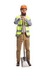 Site engineer with a vest and a helmet leaning on a shovel