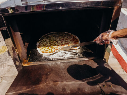 Large pizza coming out of metal oven