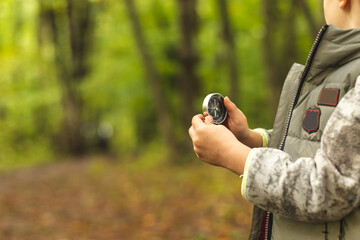Boy holding a compass in the forest