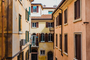 Faded and old facades of houses in the old town of the city of Verona, traditional Italian buildings.