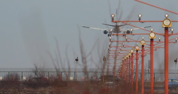 View of an airplane landing on Henri Coandă International Airport, in Otopeni City, near Bucharest, Romania, with the signal lights in sight.