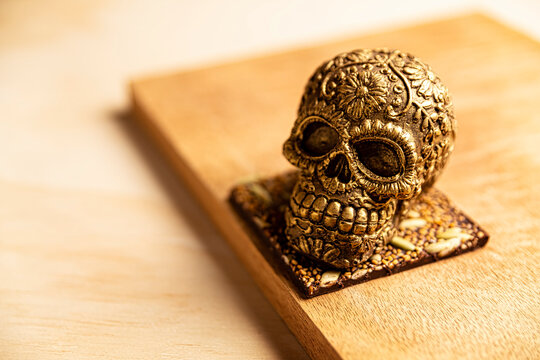 golden ornamented mexican skull made of chocolate gourmet, traditional gift for "dia de muertos" day of the death in Mexico culture named "calaverita de azucar" or "calaverita de chocolate"