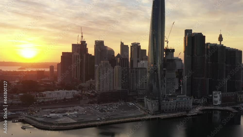 Wall mural Rising sun behind Barangaroo towers of Sydney city CBD waterfront – 4k.
