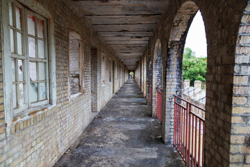 long corridor surrounded by arches and railings on the right