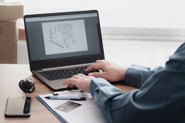 Service center staff of car use laptop check part list of car in stock and use your credit card to pay for car repair expenses spare parts smartphone checklist paper on table