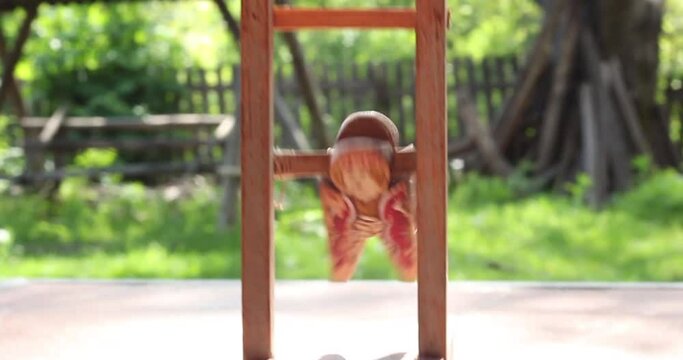 Romanian wooden toy figurine, from the 20th century, tumbling down a ladder.