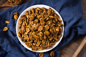 Fried Silkworm chrysalis on table,a high protein food.