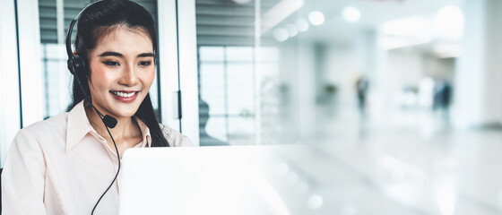 Businesswoman wearing headset working actively in office . Call center, telemarketing, customer...