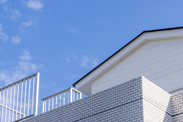 Fototapeta na wymiar 青空と家の屋根とフェンス