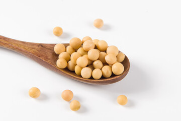 Soybean seeds in wooden spoon isolated on white background 