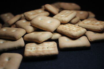 Many rectangular biscuits with small pores on black floor
