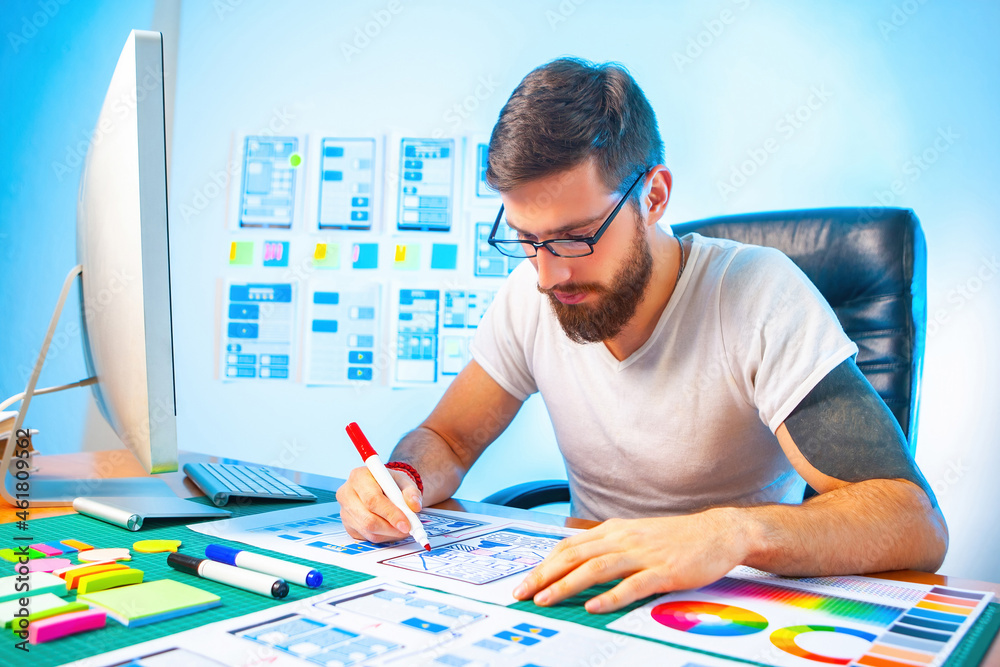Poster creation of a mobile version of site. man works in a studio to create websites. mockups of mobile ap