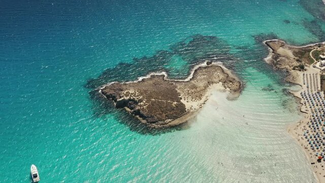 Turquoise Sea Water Rocky Island Resort. People Relax On Summer Vacation At Tropical Sand Beach. Nature Background. Travel Destinations. Beautiful Wild Coastal Landscape. Aerial Top Down View, Zoom In