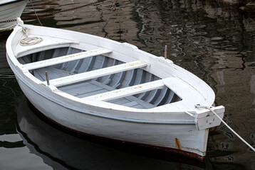 White moored boat on a river are ocean with rope and reflection. Selective focus