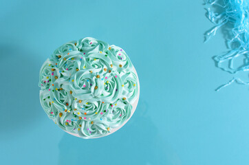 Cake decorated with blue flowers on a photo studio background.