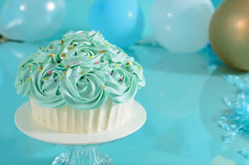 Cake decorated with blue flowers on a photo studio background.