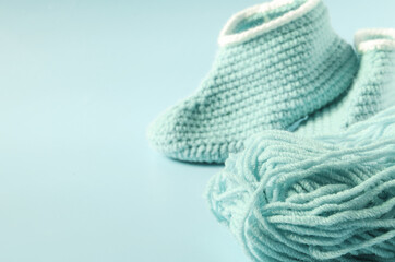 A ball of colored yarn handmade shoes and knitting accessories close-up copy space