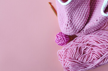 A ball of colored yarn handmade shoes and knitting accessories close-up copy space