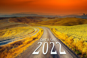 New year 2022 concept. Text 2022 written on the road in the middle of asphalt road at sunset....