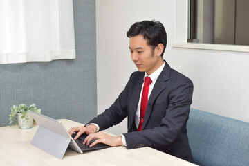 A young Asian man works at home as telework