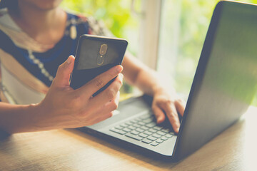 businesswoman   using mobile phone during video conversation in internet via net-book with staff during her woking outdoor office, while is sitting in cafe