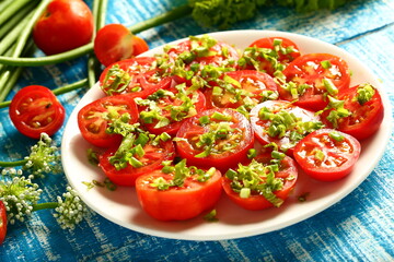 Delicious and healthy organic tomato salad with fresh herbs and green leaves.