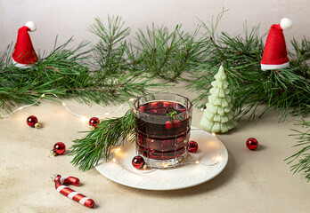 Festive Christmas Cranberry and rosemary cocktail with ice on the holiday's decorated background....